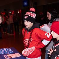 Hunter RIch helping young girl spin prize wheel at Merch table
